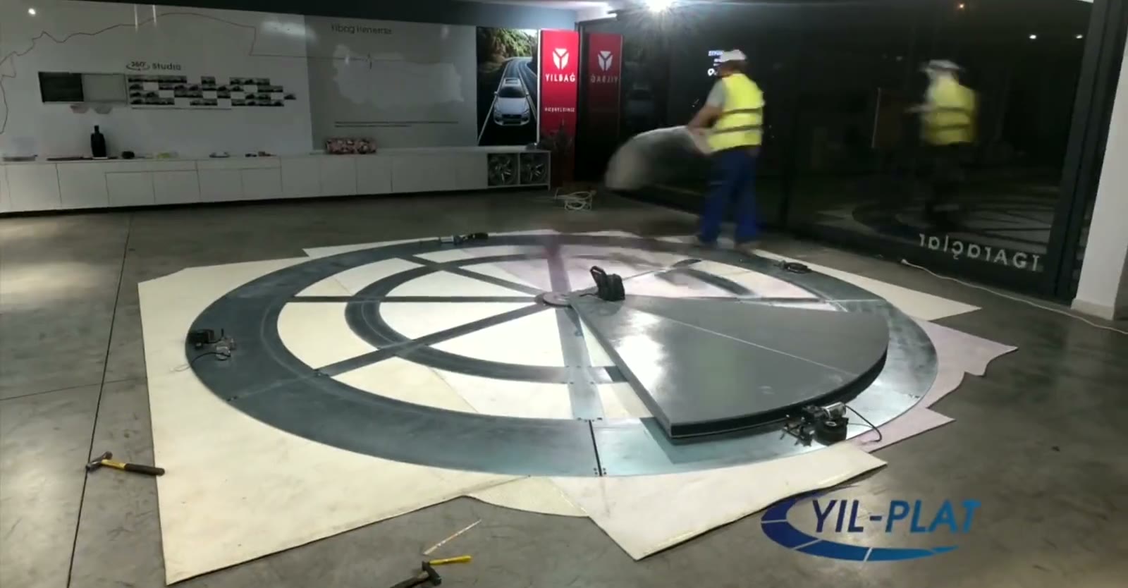YılPlat car turntable being installed on an existing showroom floor