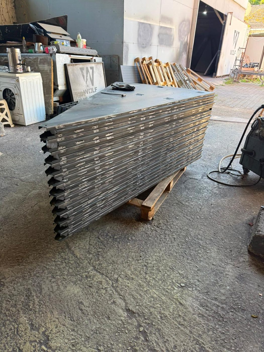 Raw galvanised-steel YılPlat deck panels stacked on a pallet at the factory
