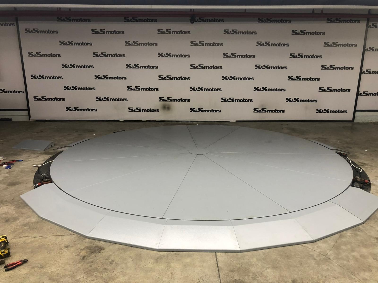 A YilPlat car turntable on a showroom's existing concrete floor, with no pit